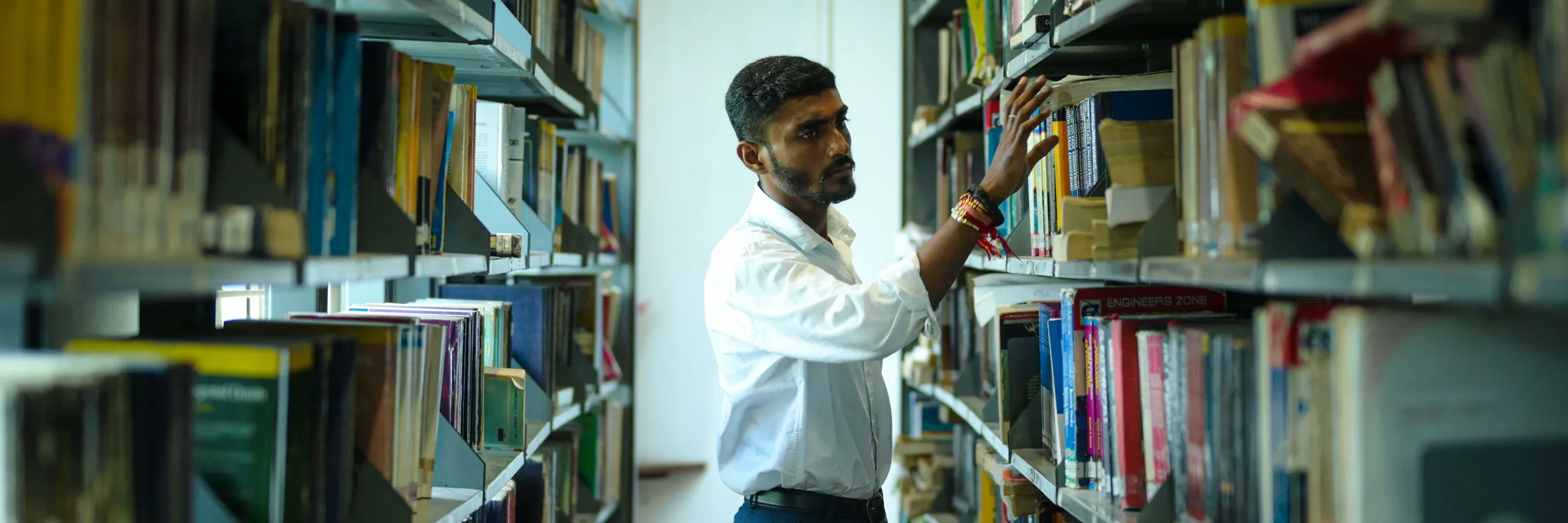 A student browsing shelves in a university library